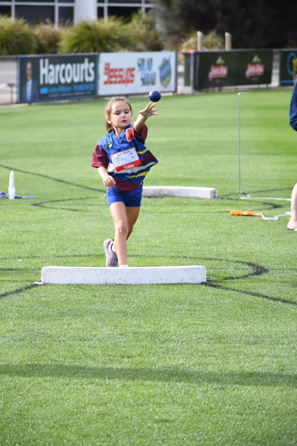 Young athlete throwing shot put