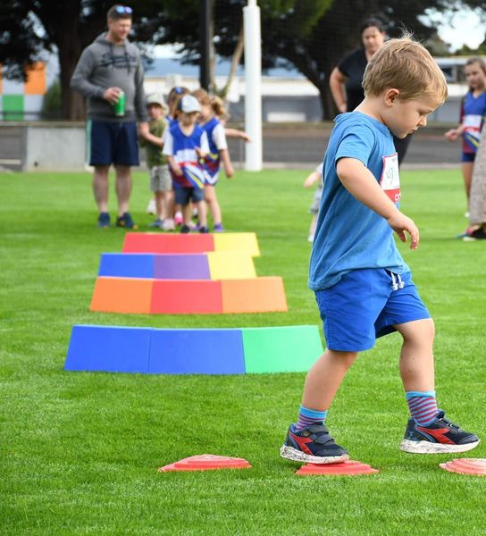 Tiny Tot stepping across coloured markers on an obstacle course